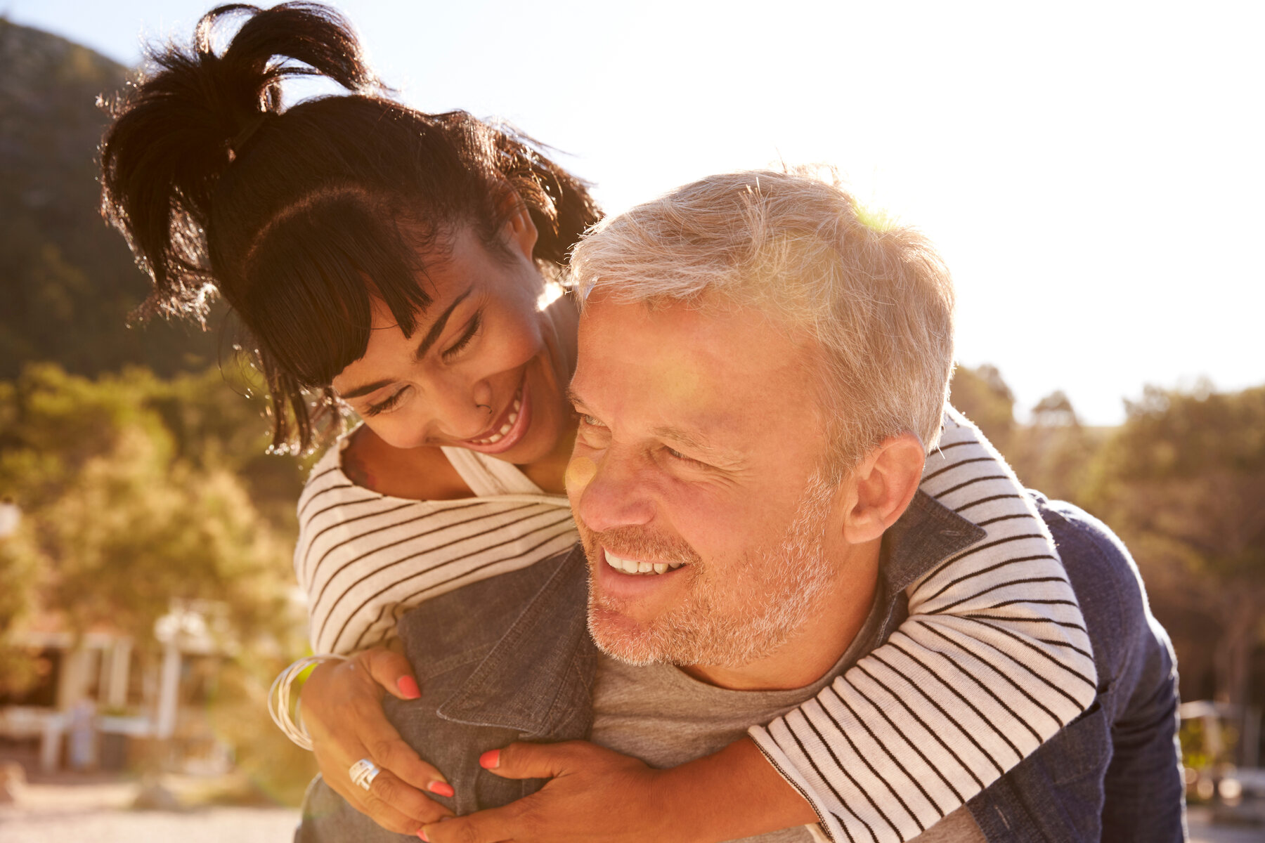 A couple laughing outdoors in the sun